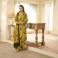 Woman in a yellow floral outfit standing in a well-lit room with wooden furniture.