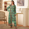 Woman wearing a green floral traditional outfit in a room with a fireplace and chair.
