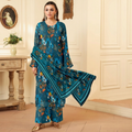 Woman wearing a blue floral traditional outfit in an elegant room.