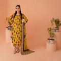 Woman in a yellow floral dress with a colorful scarf standing against a peach background with potted plants.